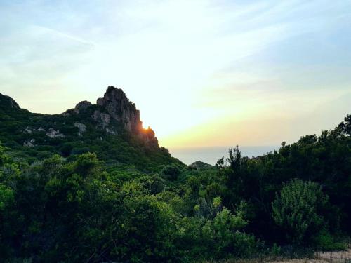 a mountain with the sun setting behind it at Villa Stella in Costa Paradiso