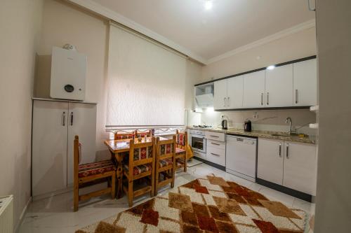 a kitchen with white cabinets and a table and chairs at Kapadokya Hatice Ana Tatil Evi in Urgup