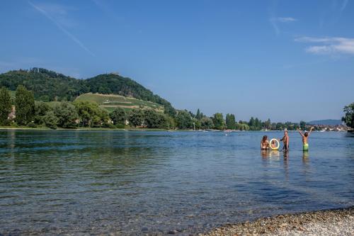 a group of people standing in the water at Camping Wagenhausen in Wagenhausen