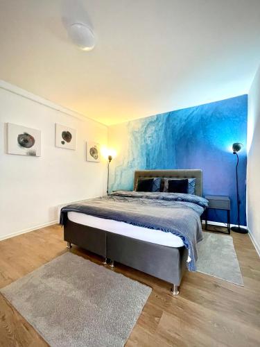 a bedroom with a bed with a blue wall at Apartman BRONX Prijedor in Prijedor