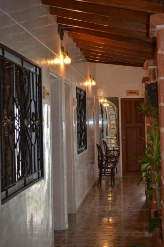 a hallway of a house with a table and chairs at Selva María Hotel Boutique in Santa Fe de Antioquia