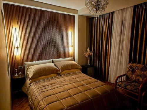 a bedroom with a large bed and a chair at Blloku Suites, City Centre,Tirana in Tirana