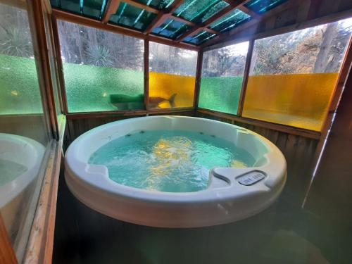 uma banheira na casa de banho com uma janela em "PINARES DEL MAR" Pequeñas cabañas ECO rusticas sello "S" em Isla Negra