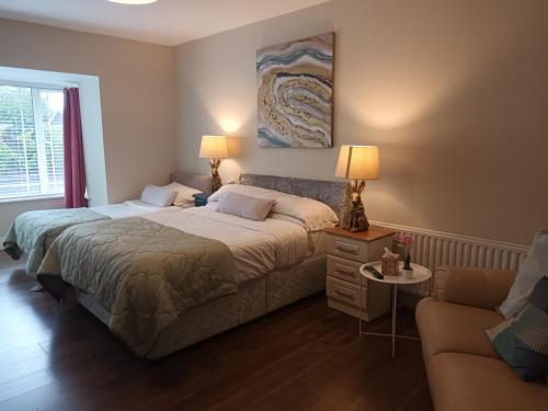 1 dormitorio con 2 camas y sofá en Mulberry Lodge en Blarney