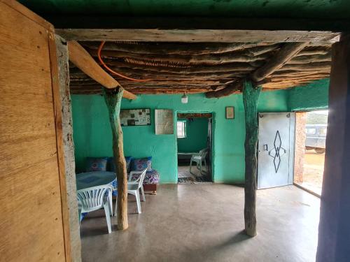 Zimmer mit grünen Wänden sowie einem Tisch und Stühlen in der Unterkunft Gite Ain Bechar in Taza