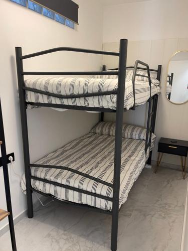two bunk beds in a room with a mirror at Castillo Principal in Almansa