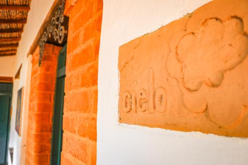 a brick wall with a sign on the side of a building at Hotel Spa El Cogollo By MH in Barichara