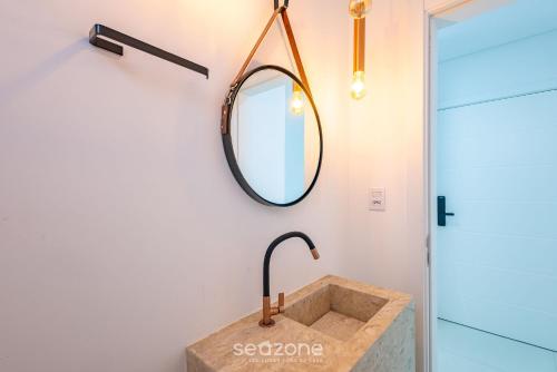 een badkamer met een wastafel en een spiegel bij Apto 3 suítes próximo ao mar Itapema-SC VGA1002 in Itapema