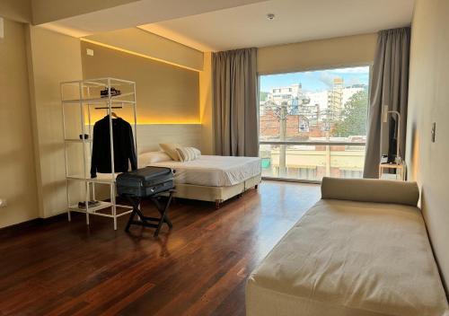 a hotel room with a bed and a window at Roomie Salta by DOT Suites in Salta