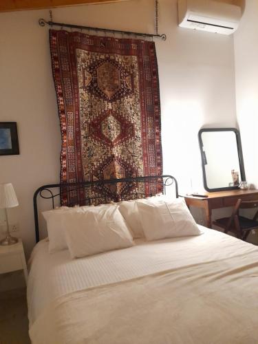 a bedroom with a bed with a tapestry on the wall at Ble Mavi - Studio for 2 in Vouni