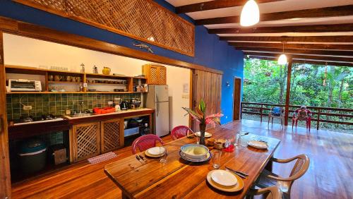 a dining room with a wooden table and a kitchen at Pincoya in Punta Uva