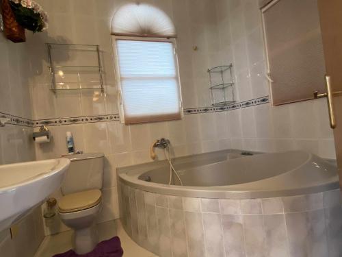 a bathroom with a tub and a toilet and a sink at Encantadora VILLA con piscina en Playa Flamenca in Alicante