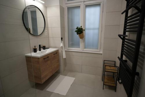 baño con lavabo, espejo y ventana en DS36 Budapest-Belvárosi lakás, en Budapest