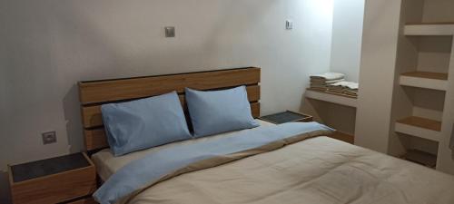 a bedroom with a bed with two blue pillows at Foivos Apartment in Komotini