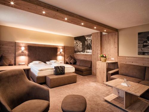 pokój hotelowy z łóżkiem i kanapą w obiekcie Alpinresort Stubaierhof ****s w mieście Fulpmes