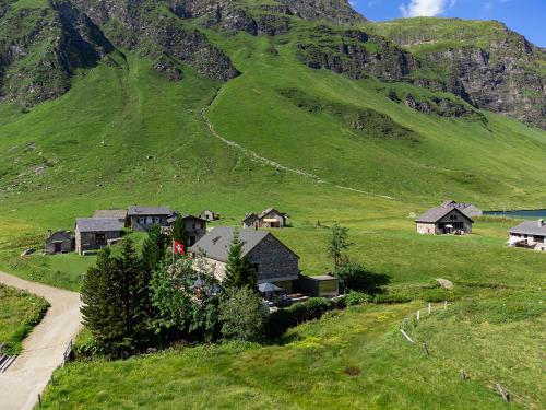 a village on a green hill with a mountain at RISTORO TANEDA in Quinto