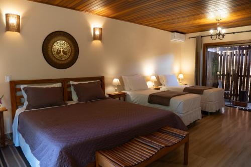 a hotel room with two beds and a window at Pousada Lua Clara in Alto Paraíso de Goiás