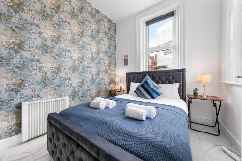 a bedroom with a large bed with towels on it at Modern 2 Bedroom Flat - Near Primrose Hill, Camden Market, Regent's Park - Good Links to Kings Cross, Euston, Finchley Road Station - NW3 London in London