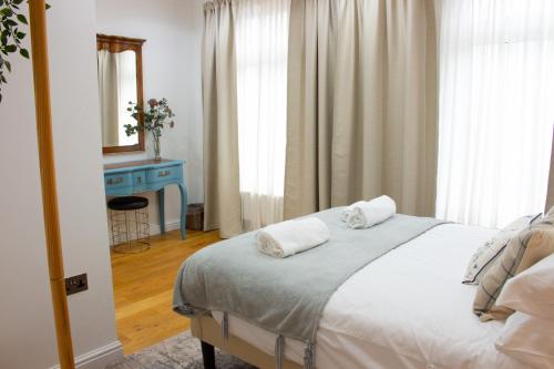 ein Schlafzimmer mit einem Bett mit zwei Handtüchern darauf in der Unterkunft Elegant 4 bedroom, Maidstone house by Light Living Serviced Accommodation in Maidstone