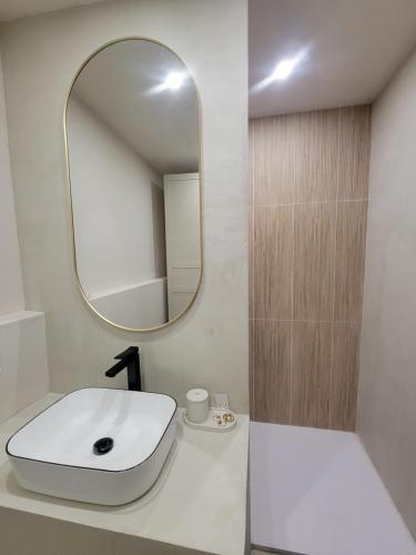 une salle de bain avec un lavabo blanc et un miroir dans l'établissement Maison familiale avec piscine, à Tresses