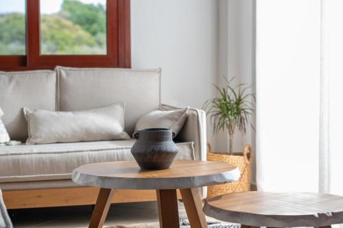 a living room with a couch and a vase on a table at Xenonas Apollon in Sarti