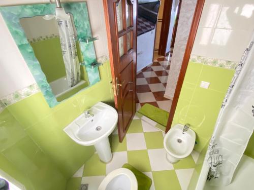 W łazience znajduje się umywalka, toaleta i lustro. w obiekcie Lina confort a tanger w mieście Tanger