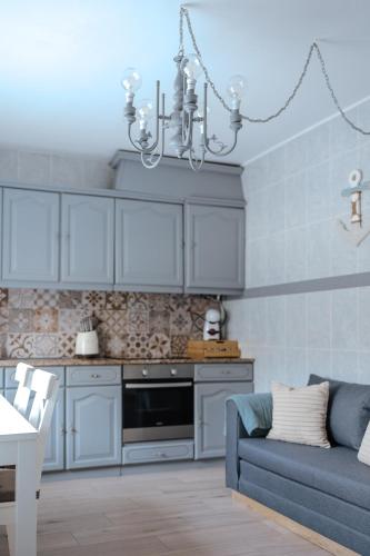 a kitchen with a blue couch and a chandelier at Casa da Sereia in Leiria