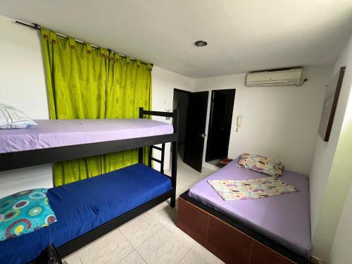 2 Etagenbetten in einem Zimmer mit grünem Vorhang in der Unterkunft Hotel Villa Sofia in Villavicencio
