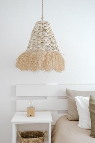 a pendant light hanging over a bed with a table at Casa da Sereia in Leiria