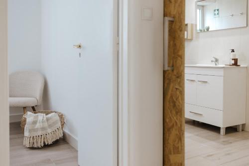 a kitchen with a white refrigerator and a sink at Casa da Sereia in Leiria