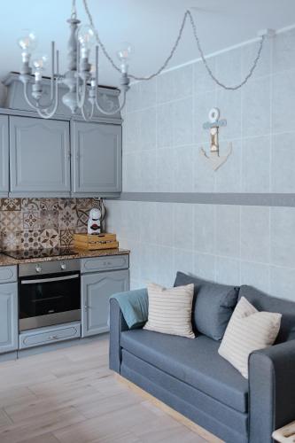 a living room with a blue couch and a kitchen at Casa da Sereia in Leiria