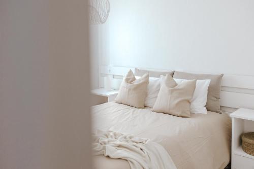 a bedroom with a white bed with white pillows at Casa da Sereia in Leiria