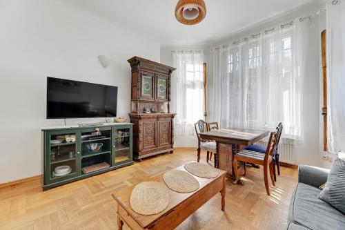 a living room with a table and a tv at Park Winieckiego Apartment by Grand Apartments in Sopot