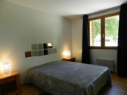 une chambre avec un lit et une grande fenêtre dans l'établissement HERMITAGE, à Anzex