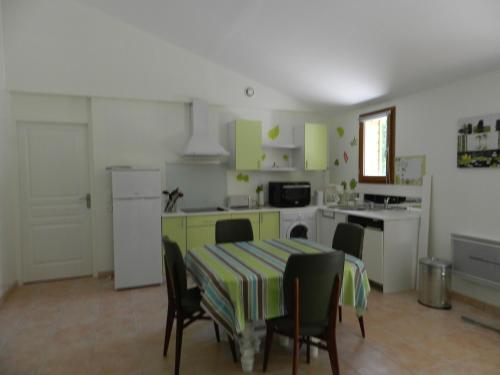 une cuisine avec une table et des chaises et une cuisine avec des armoires vertes dans l'établissement HERMITAGE, à Anzex