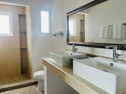 a bathroom with a sink and a toilet and a mirror at Brand new penthouse with plunge pool, amazing top view in Isla Mujeres