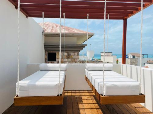 two beds on the balcony of a house at Brand new penthouse with plunge pool, amazing top view in Isla Mujeres