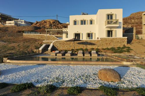 a villa with a swimming pool and a house at Seawinds' Soul Villa in Houlakia