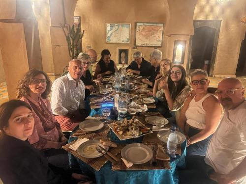 a group of people sitting around a dinner table at Riad Dar Ouzine in Merzouga