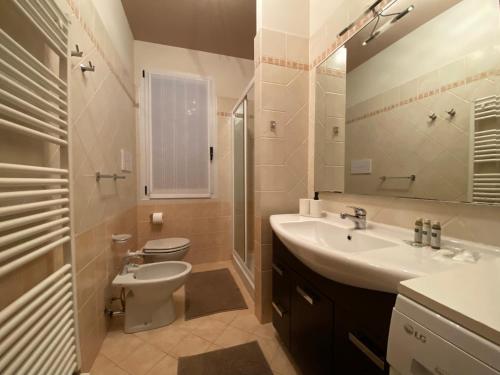 a bathroom with a toilet and a sink and a mirror at Valentina’s home in Manerba del Garda