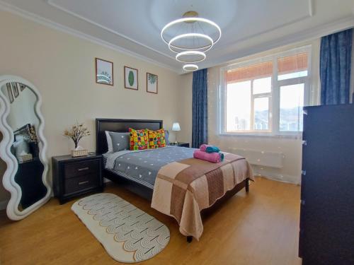 a bedroom with a bed and a large window at Tsengeldekh:Cozy 1 BR Apt•Queen bed•Naadam stadium in Ulaanbaatar