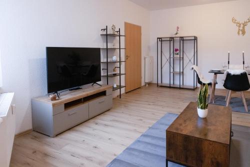 a living room with a flat screen tv on a entertainment center at Apartment Sängerstadt Flat Peter in Finsterwalde
