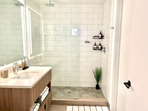 a white bathroom with a sink and a shower at Sleek & Stylish Jr. 1-BR Retreat - Las Olas in Fort Lauderdale