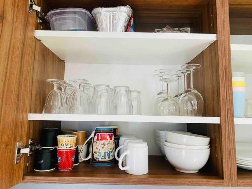 a cupboard filled with glasses and other dishes at Appartement 6 personnes les terrasses d isola2000 in Isola