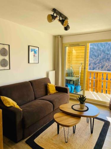 a living room with a couch and a table at Appartement 6 personnes les terrasses d isola2000 in Isola