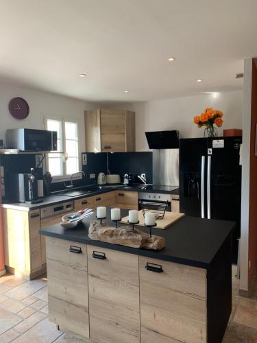 une cuisine avec un grand îlot au milieu dans l'établissement Maison 10/12 pers à 5 min du Phare des Baleines, à Saint-Clément-des-Baleines