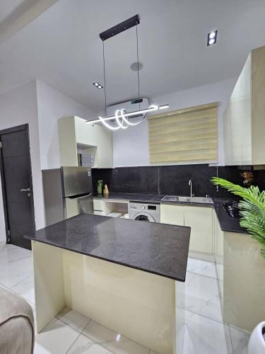 une grande cuisine avec un comptoir noir dans l'établissement Amys_Apartments, à Lagos