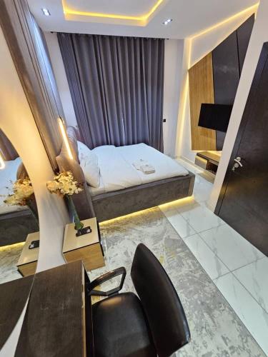 - une chambre avec un lit, une chaise et un bureau dans l'établissement Amys_Apartments, à Lagos