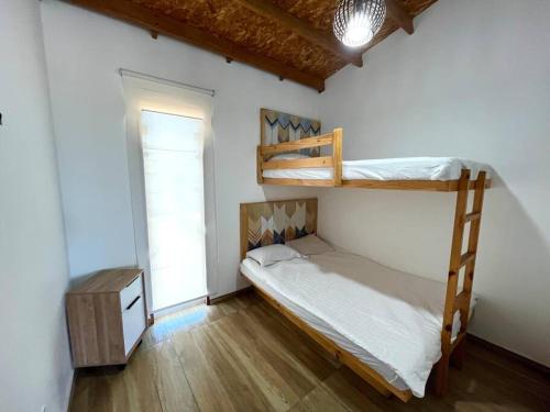 a bedroom with two bunk beds and a window at NAUTICA CHINCHA Casa con Piscina frente al mar in Casa Blanca