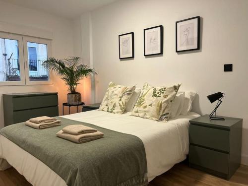 Un dormitorio con una cama grande con almohadas. en Apartamento en Santander con vistas al mar, en Santander